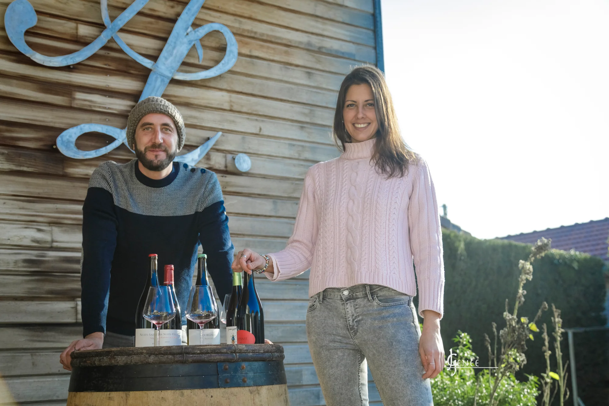 Antoine et Héloïse Lienhardt devant le domaine, bouteilles sur un tonneau